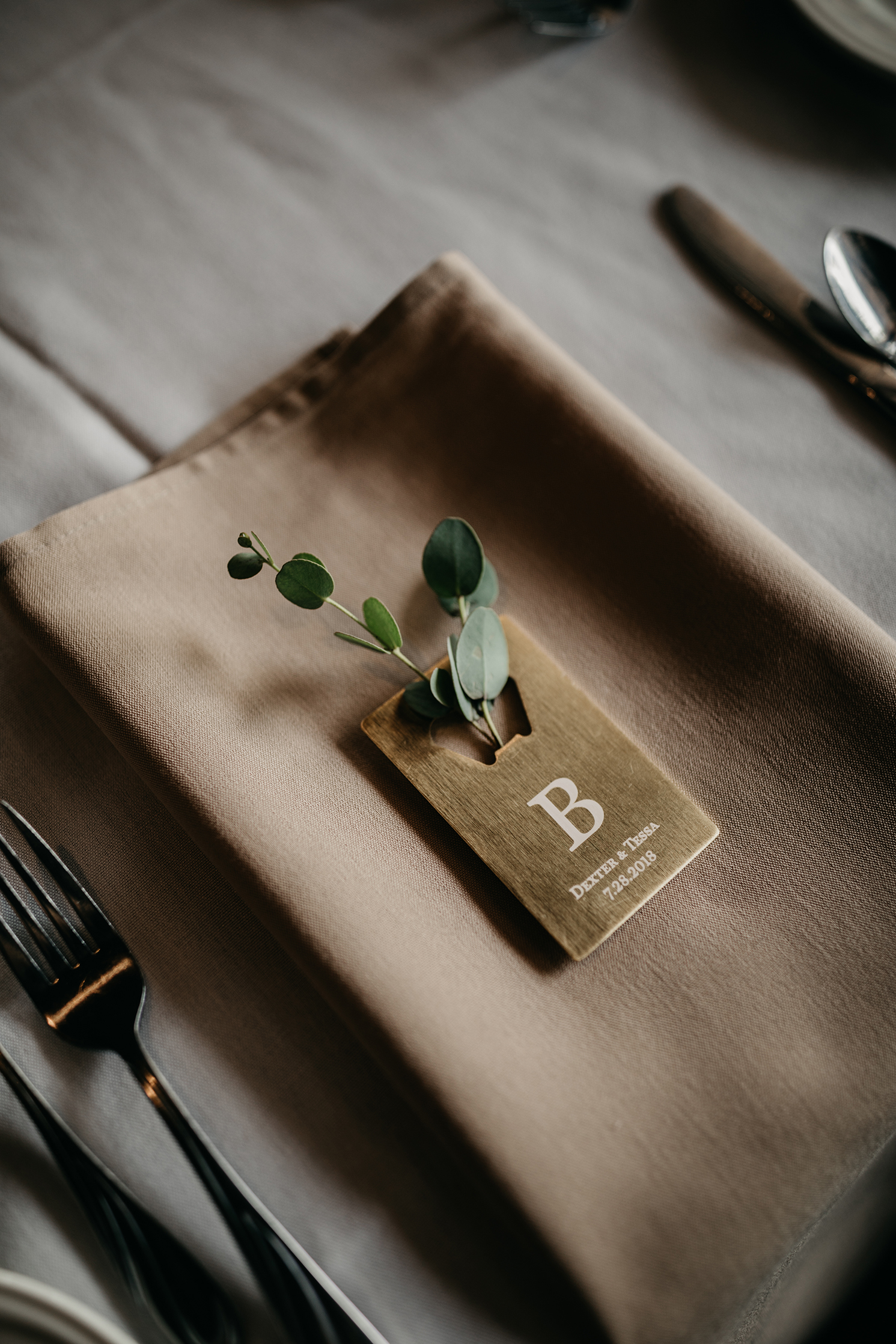 taupe neutral place setting bottle opener greenery sprigs