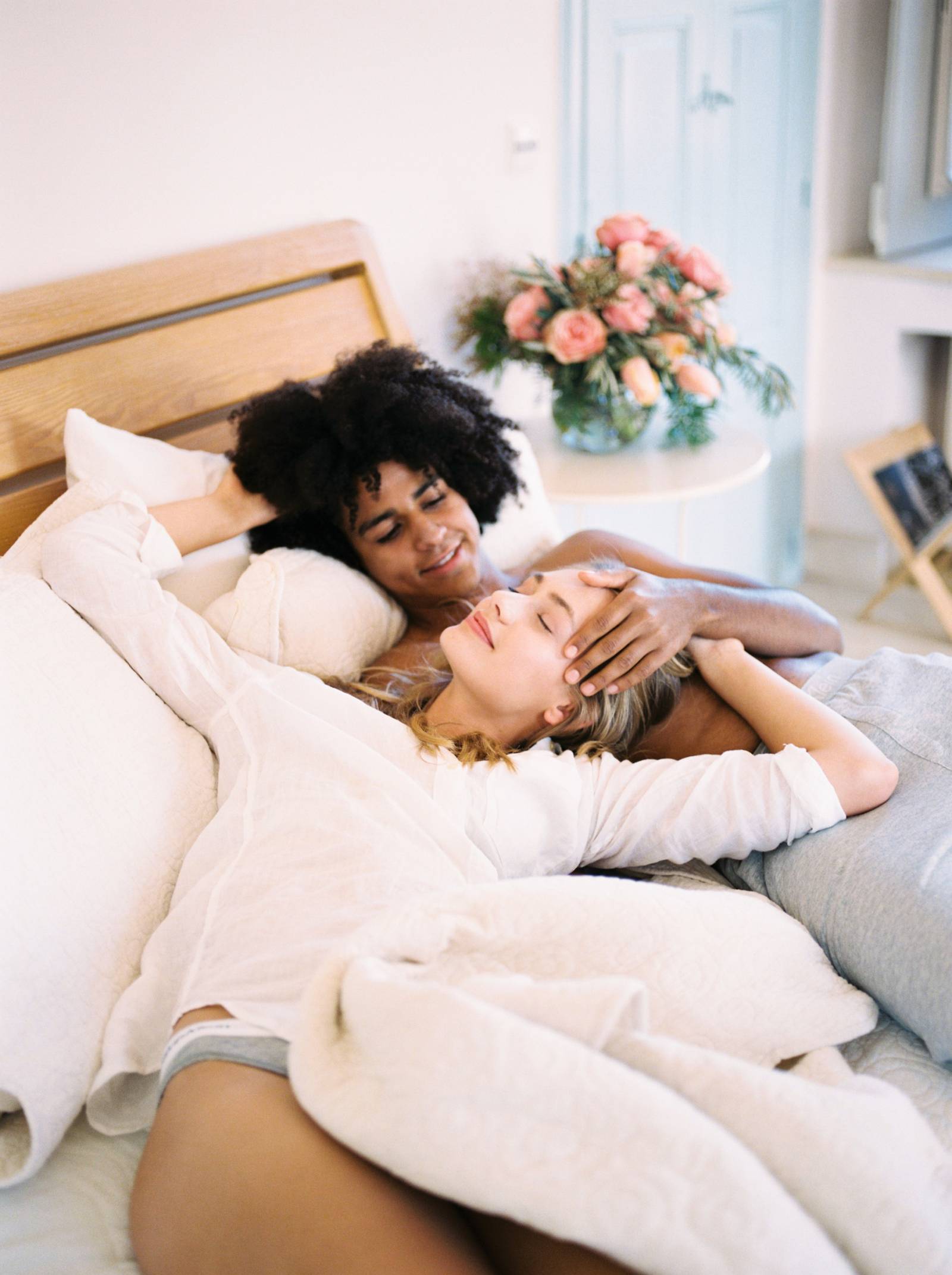 A couple cuddle up in bed together