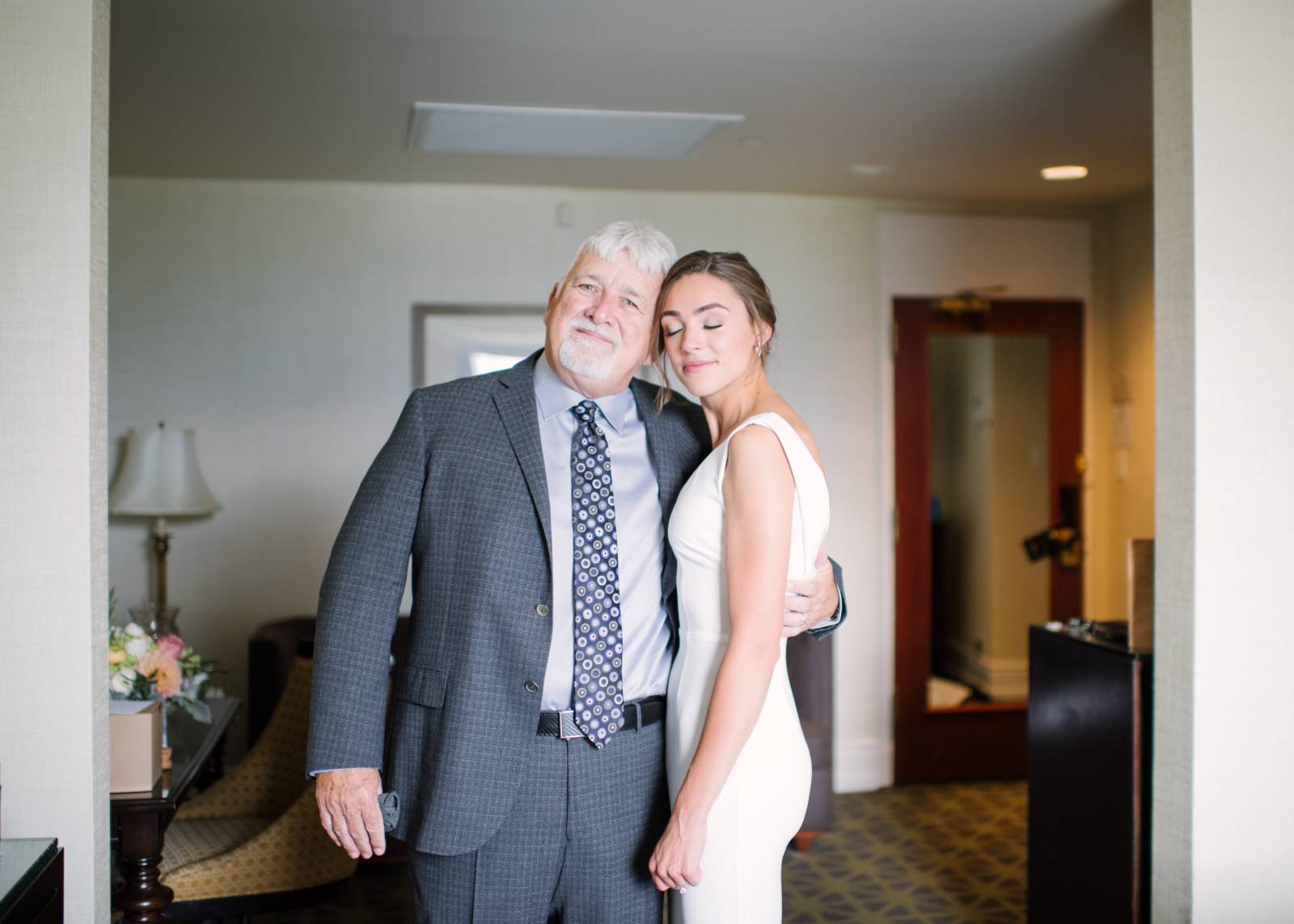 a beautiful young bride hugs her father at the Banff Springs hotel before her wedding ceremony
