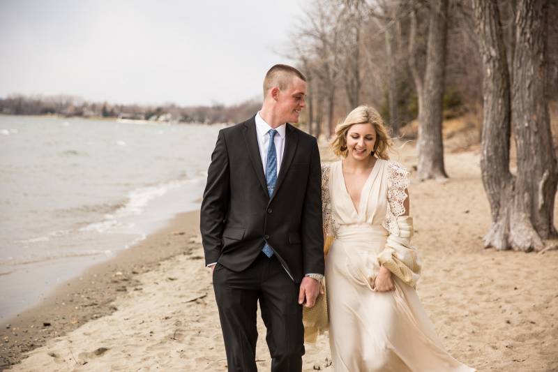 Couple walking on Leddy Beach on Lake Champlain in Burlington Vermont during spring elopement