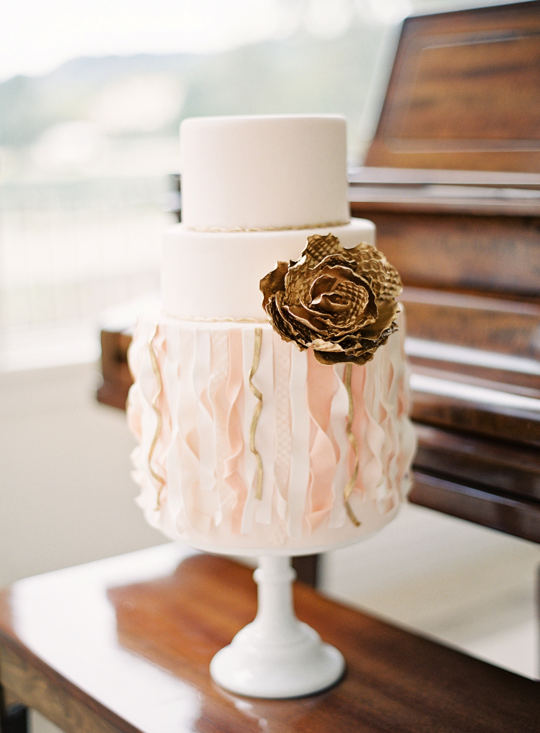 Blush and gold floral wedding cake with ruffles