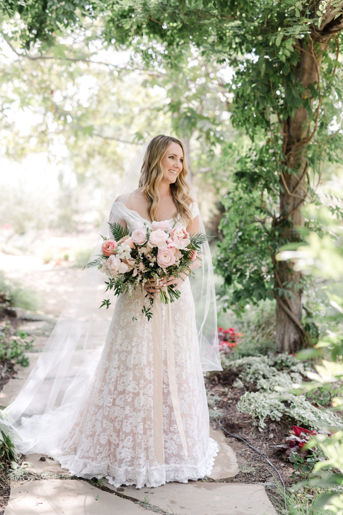 The Beautiful Bride Standing With the Bouquet of Flowers | The Wedding Standard