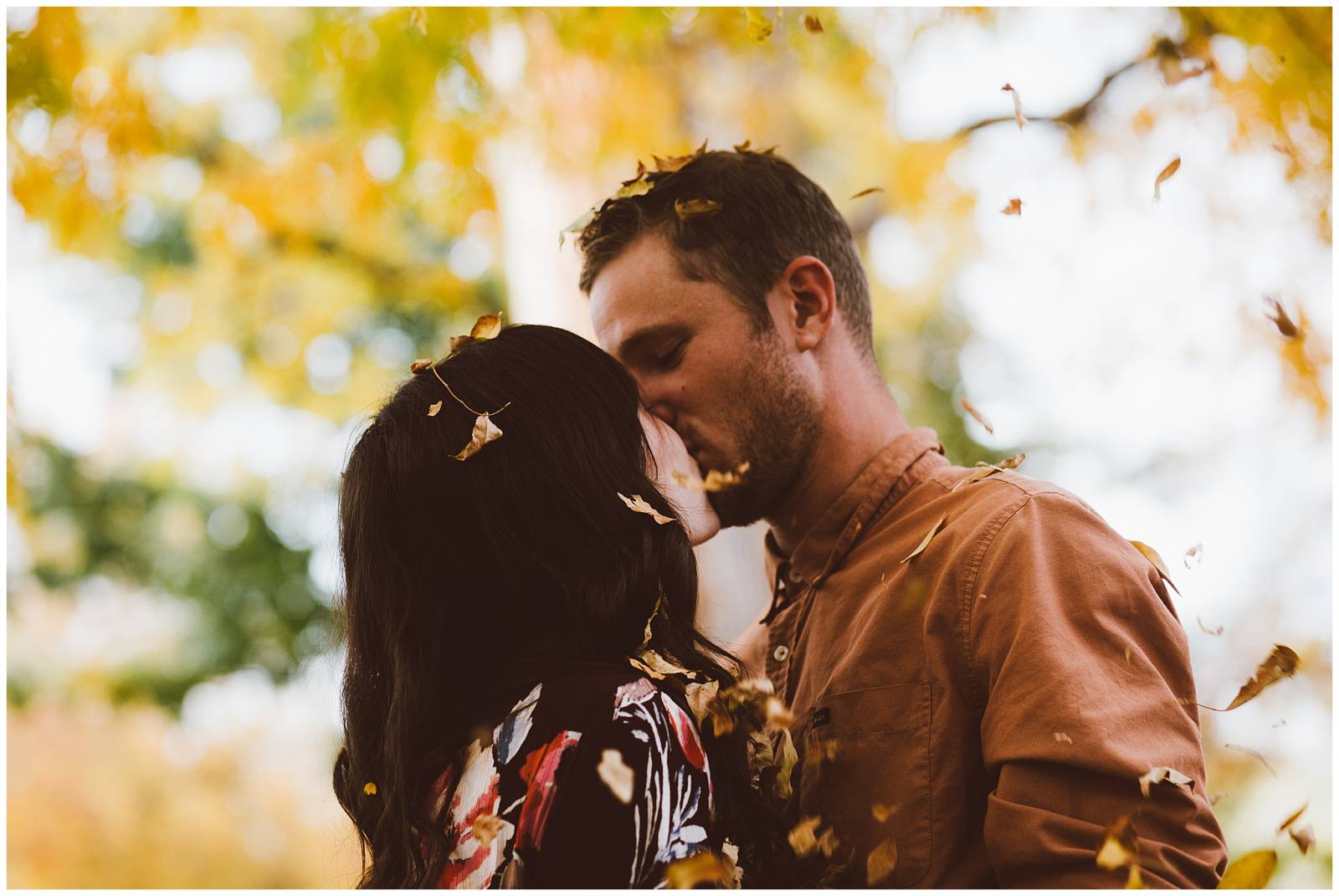 moody engagement photo inspiration | couple kissing under fall leaves