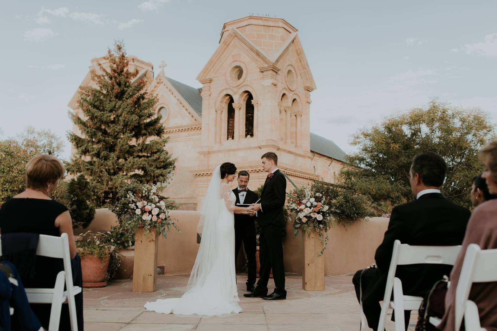 bride and groom holding hands at wedding ceremony at the La Fonda on the Plaza