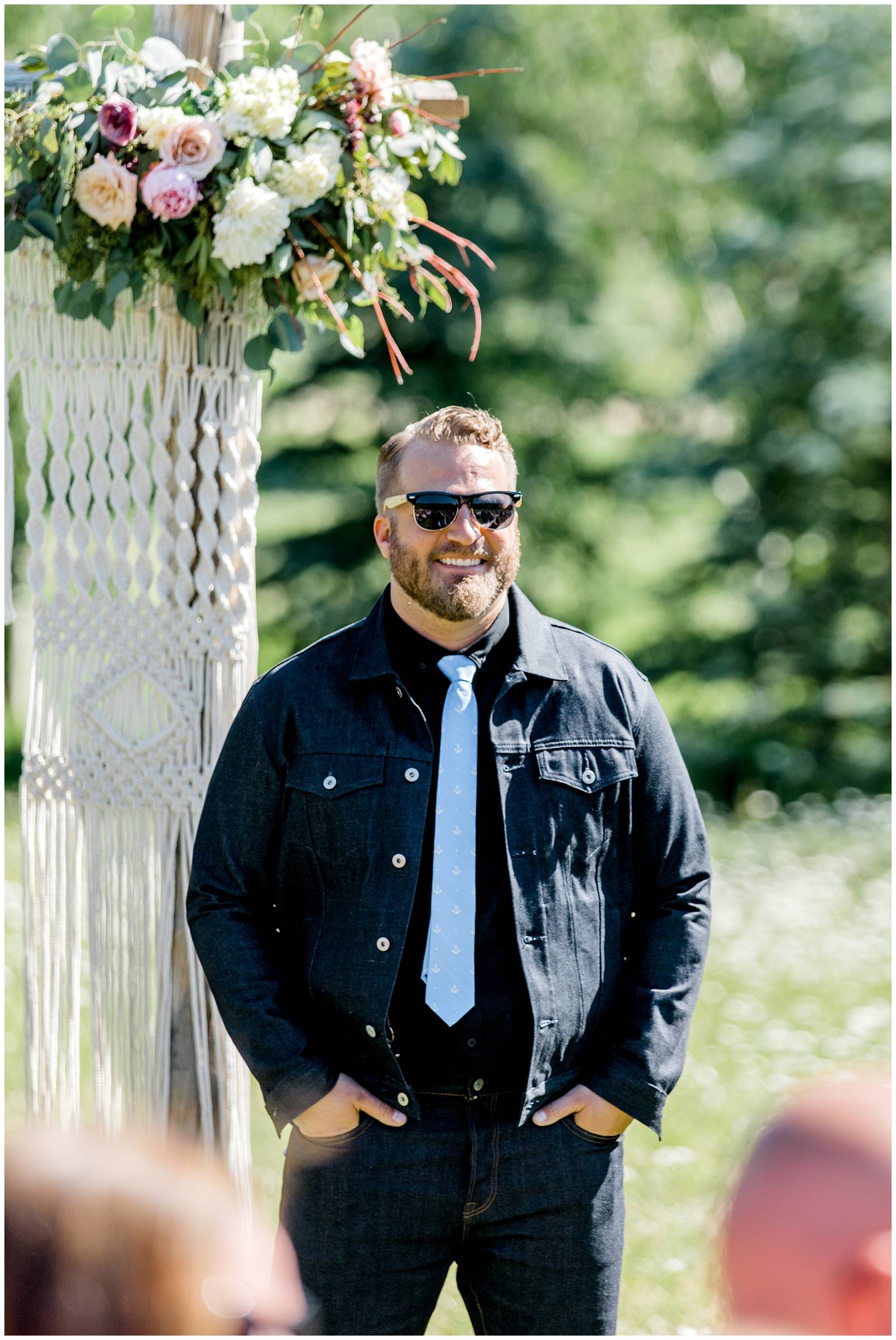 groom standing at wedding alter wearing blue polka dot tie and jean jacket