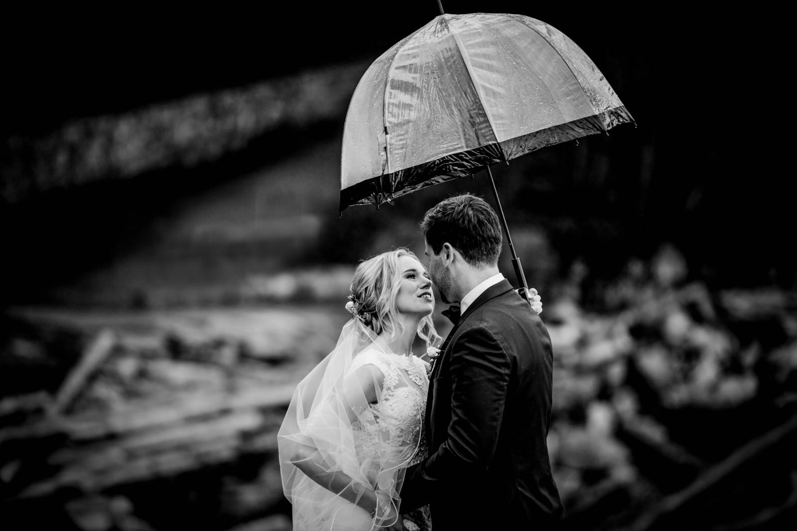 black and white photo of bride and groom under umbrella | wedding planned by Umbrella Events