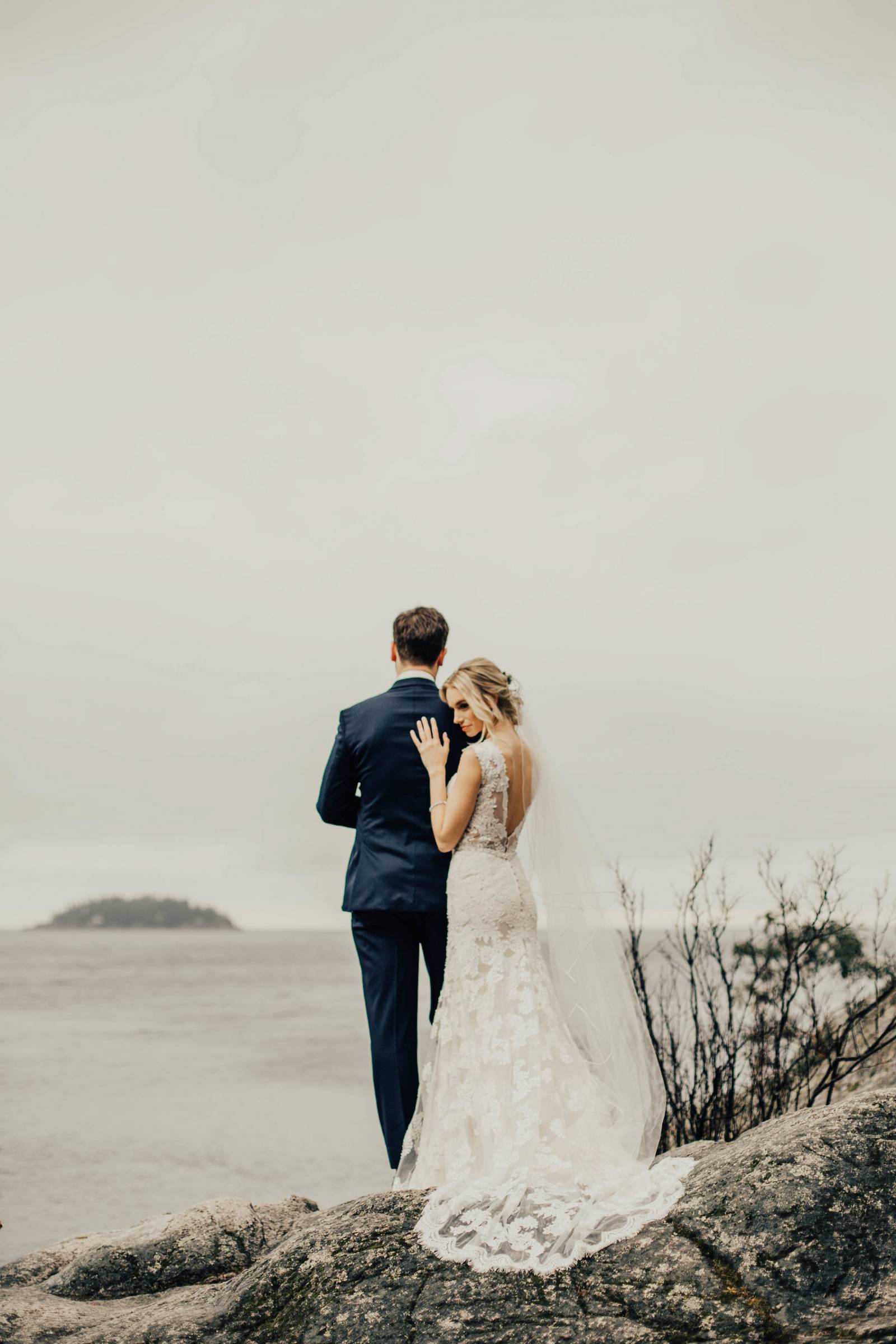 Grouse Mountain wedding day portrait near lake | bride in lace wedding gown leaning on groom's shoul