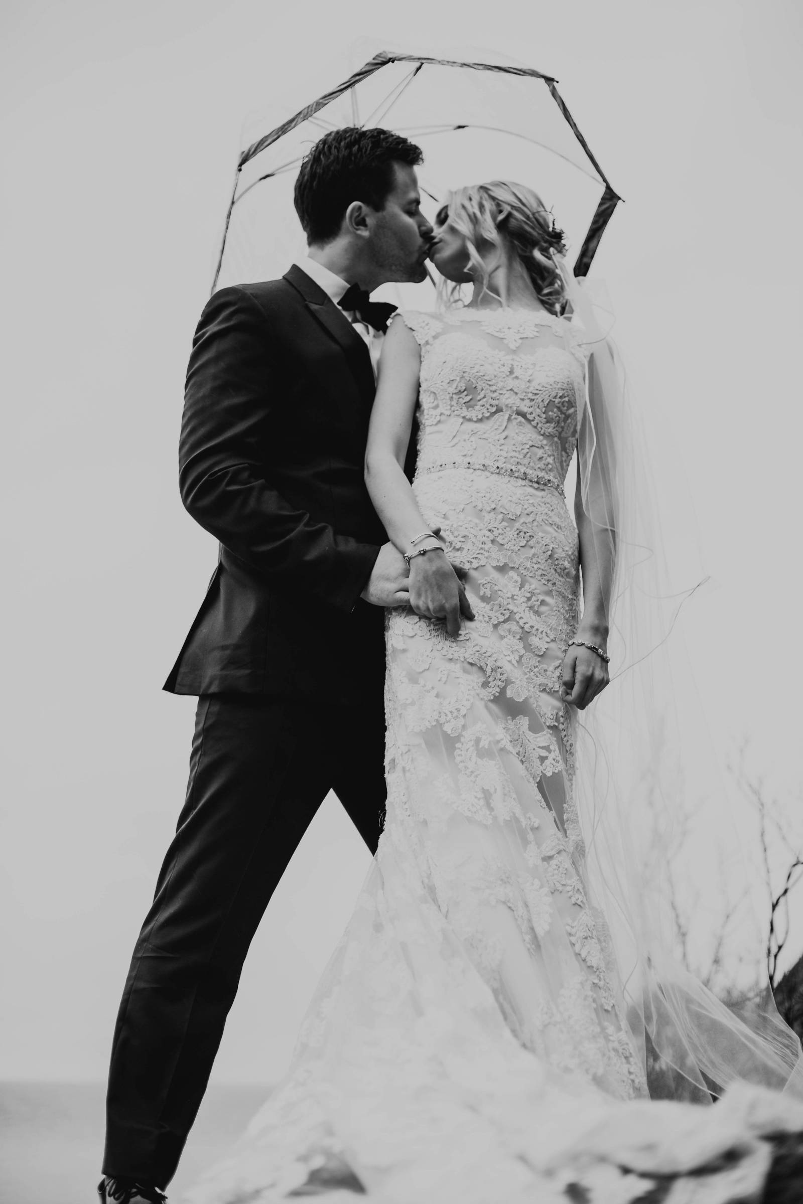 black and white photo of groom kissing bride | wedding planned by Umbrella Events at Grouse Mountain