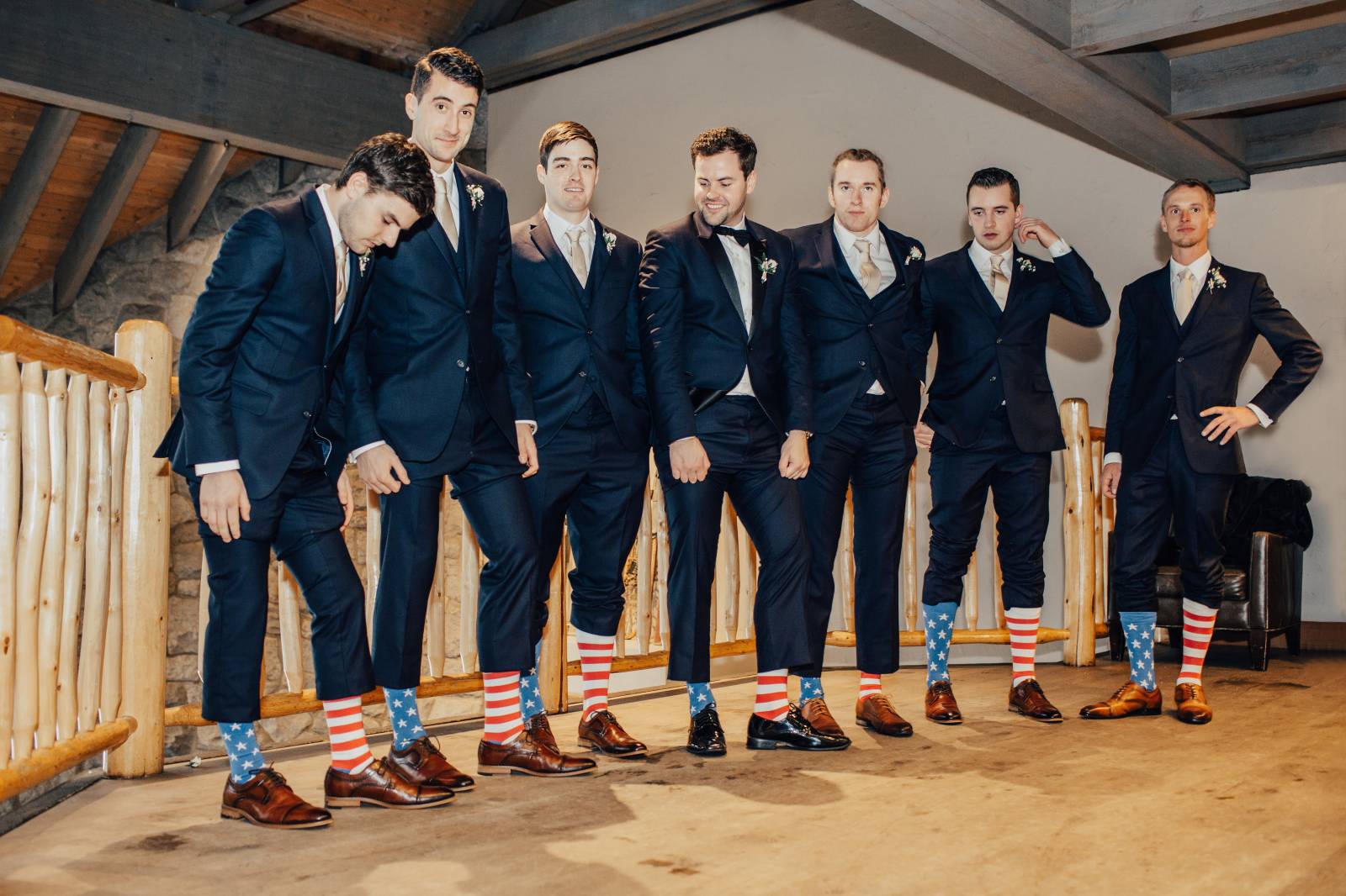 groom and groomsmen showing off american flag socks for Canadian wedding