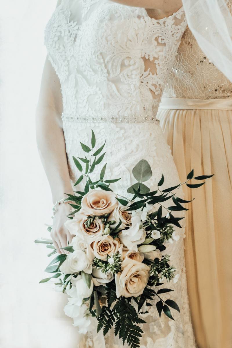 bride holding classic wedding bouquet with white and blush flowers