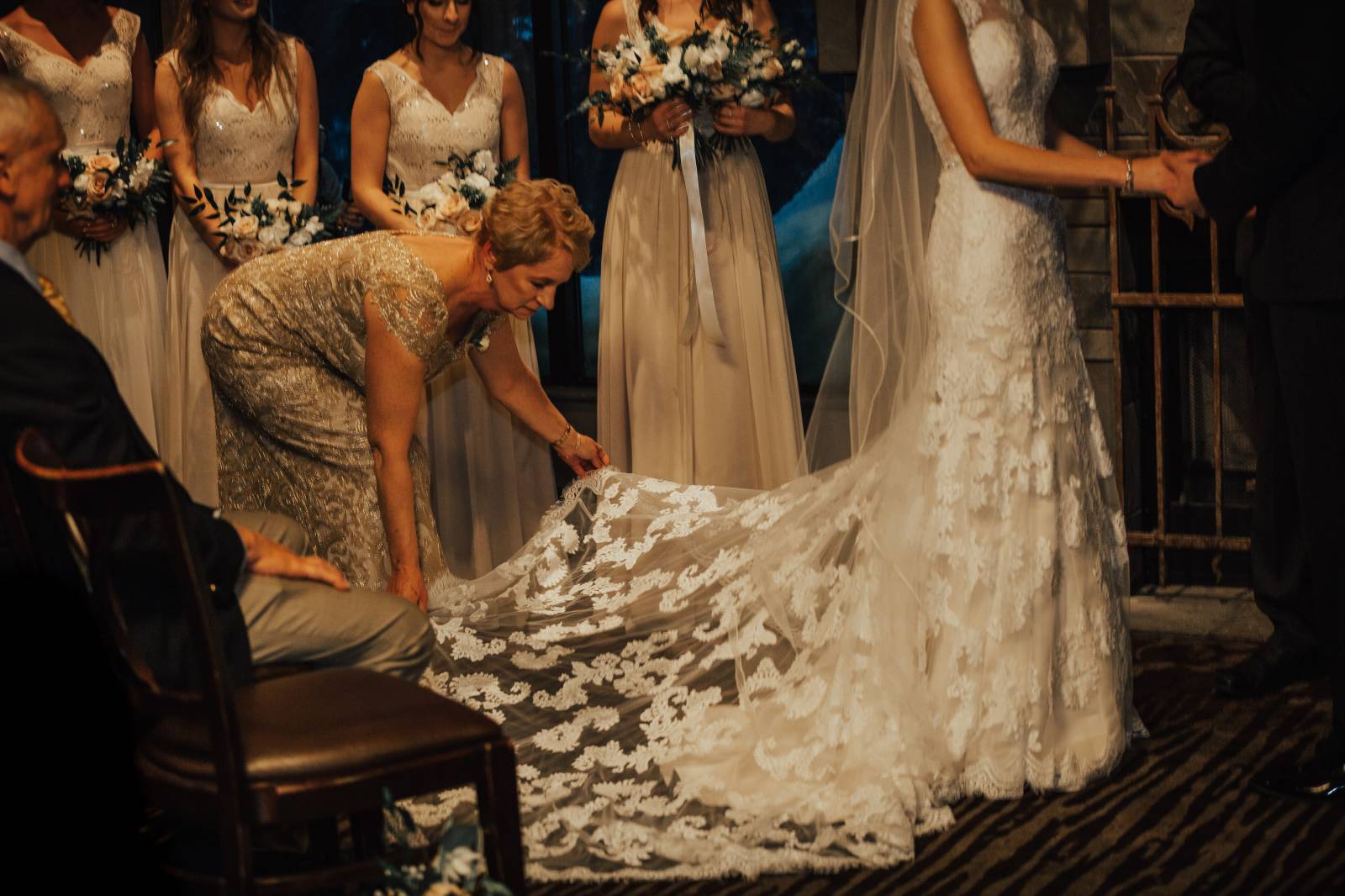 mother of the bride fixing the bride'd wedding gown train