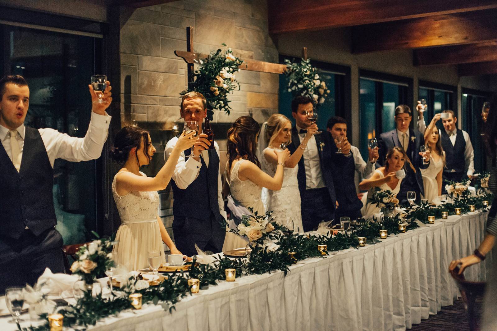 wedding party raising their glasses to cheers at wedding reception at Grouse Mountain