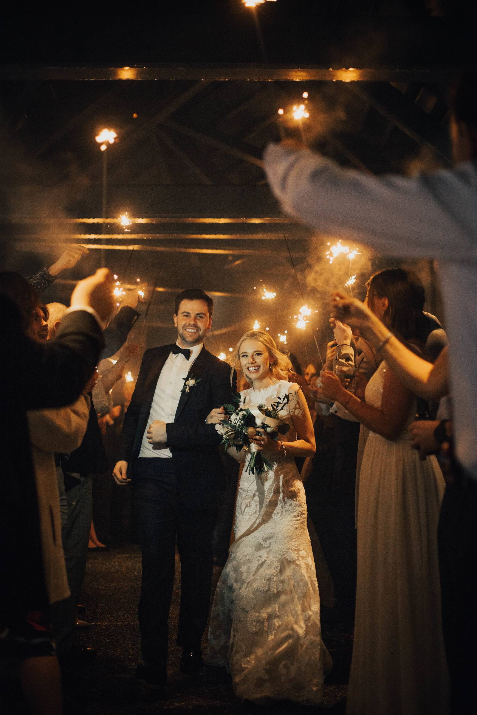 bride and groom going under the sparklers of the wedding guests