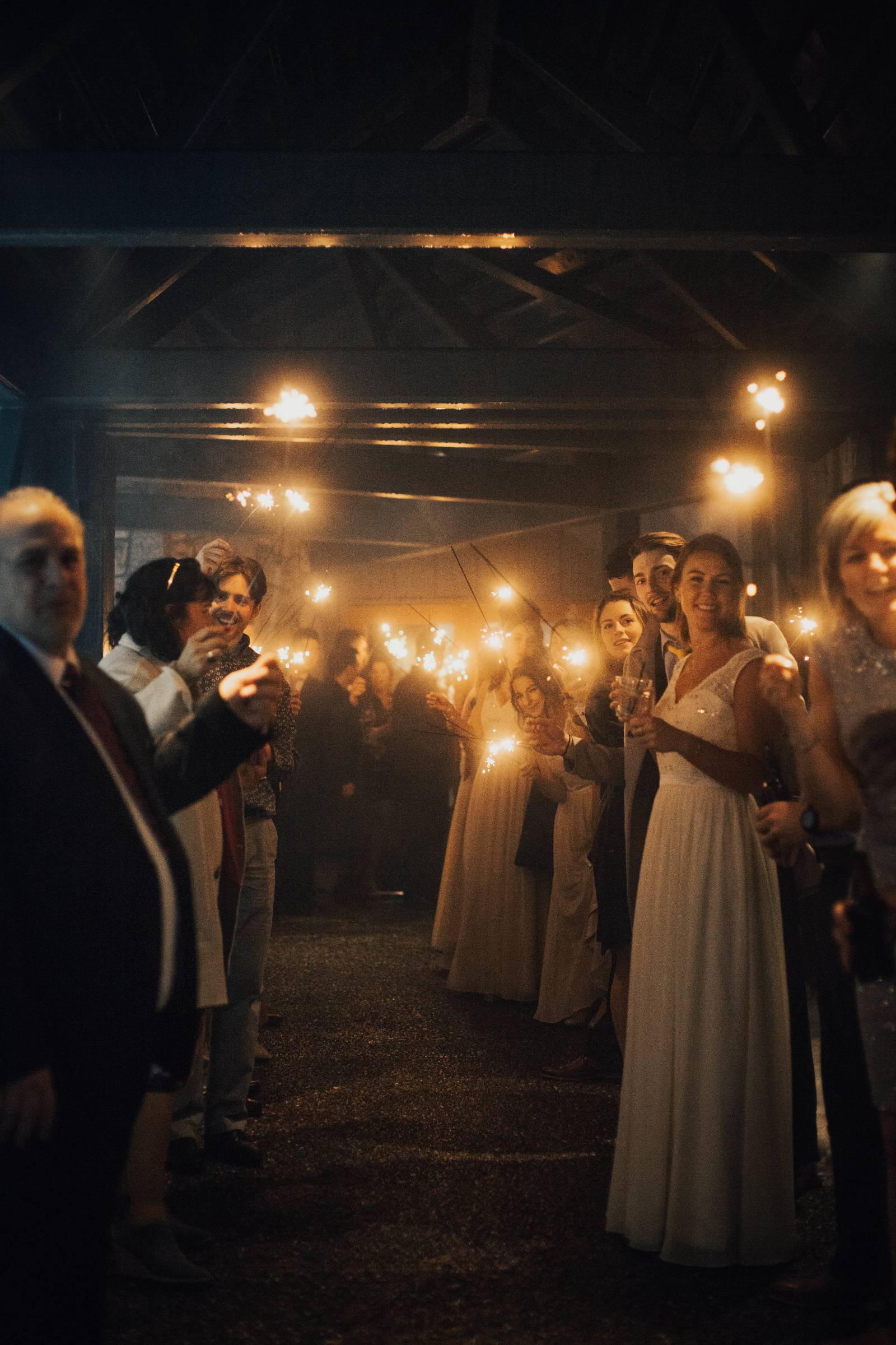 wedding guests holding up sparklers as bride and groom leave Grouse Mountain