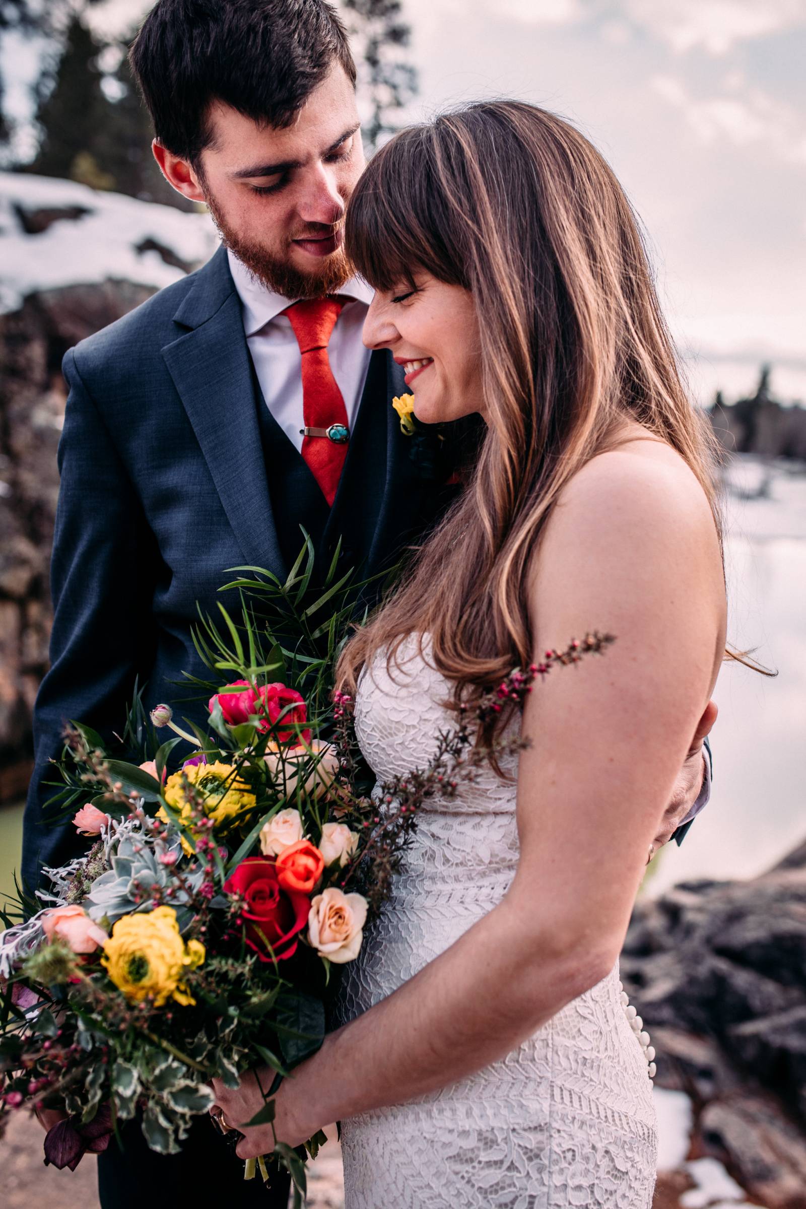portrait of bride and groom | bride with straight hair holding colorful spring bouquet