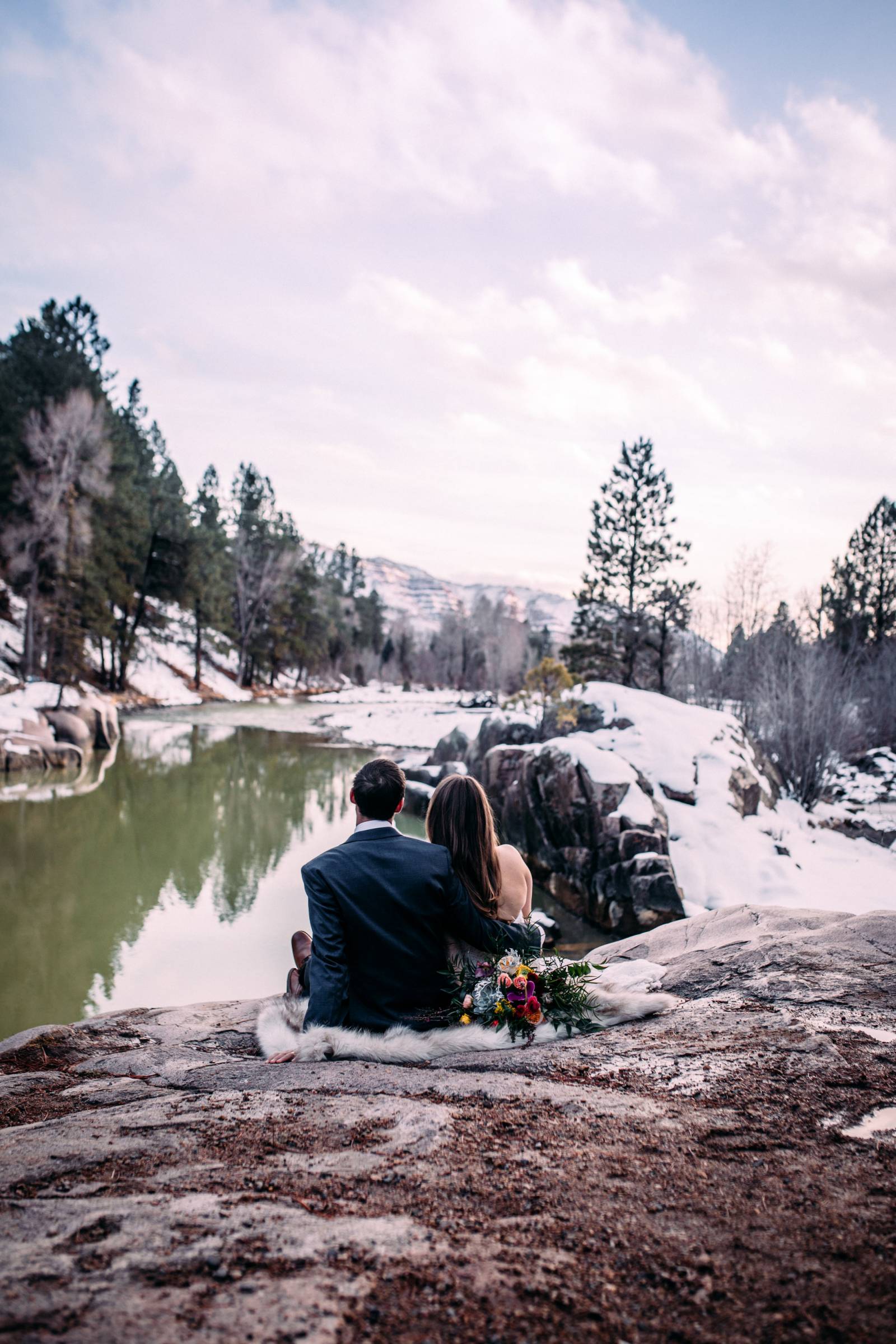 portrait of bride and groom sitting after eloping in Emerald Isle Colorado during winter