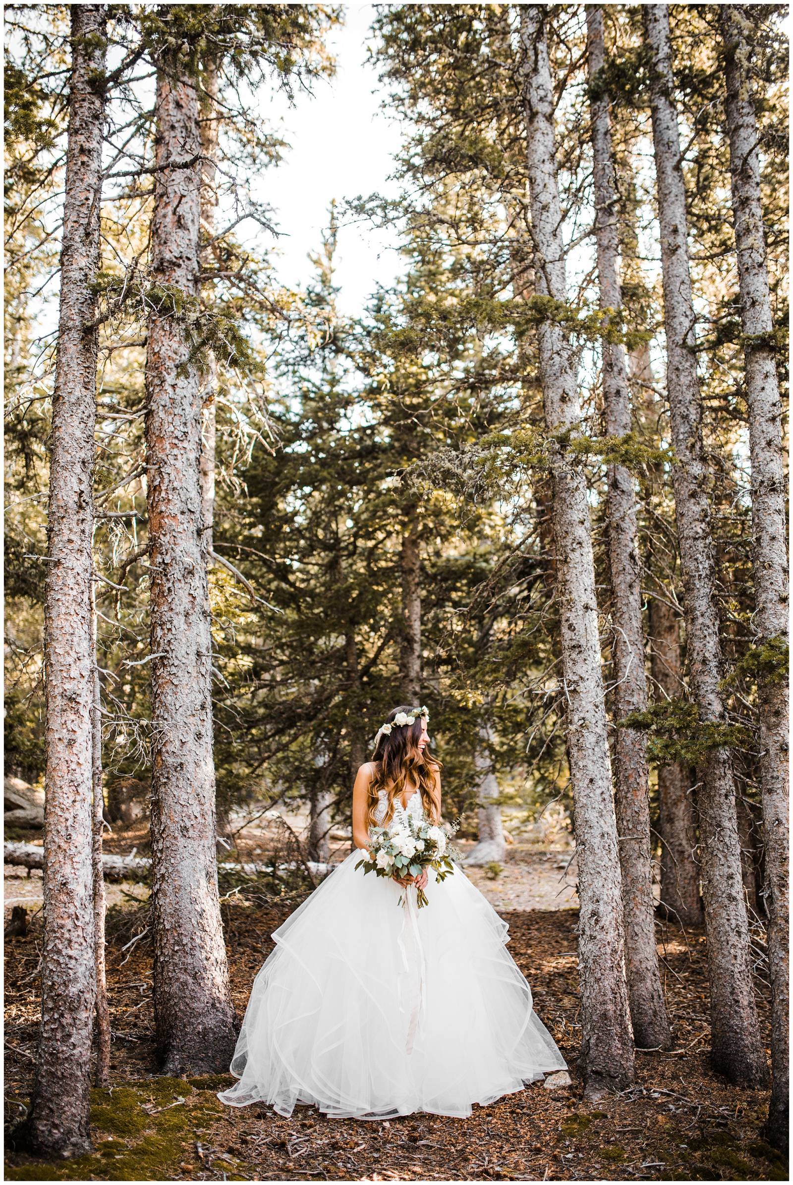 whimsical bride holding luscious bouquet standing in Colorado aspens