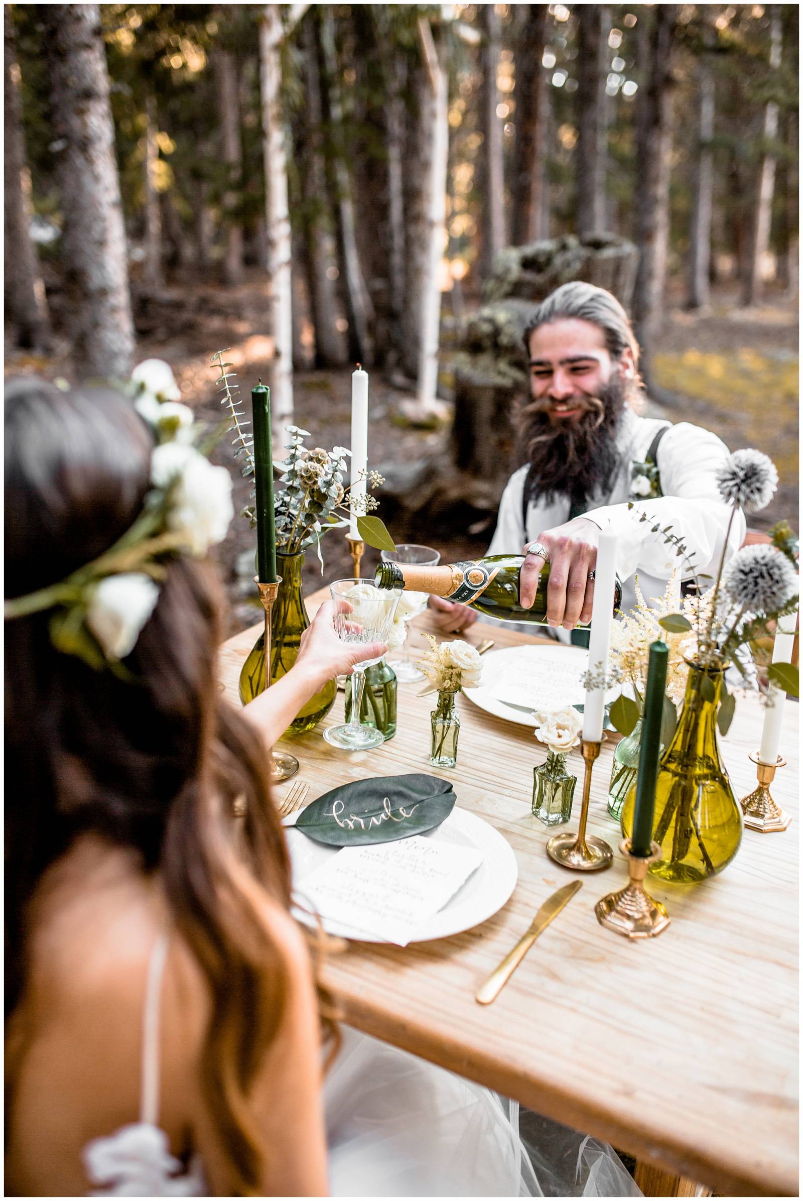 groom pouring bride champagne after mountain elopement