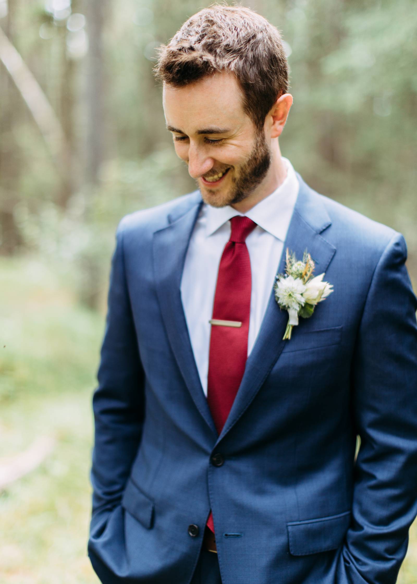 groom wearing red tie in a blue suit