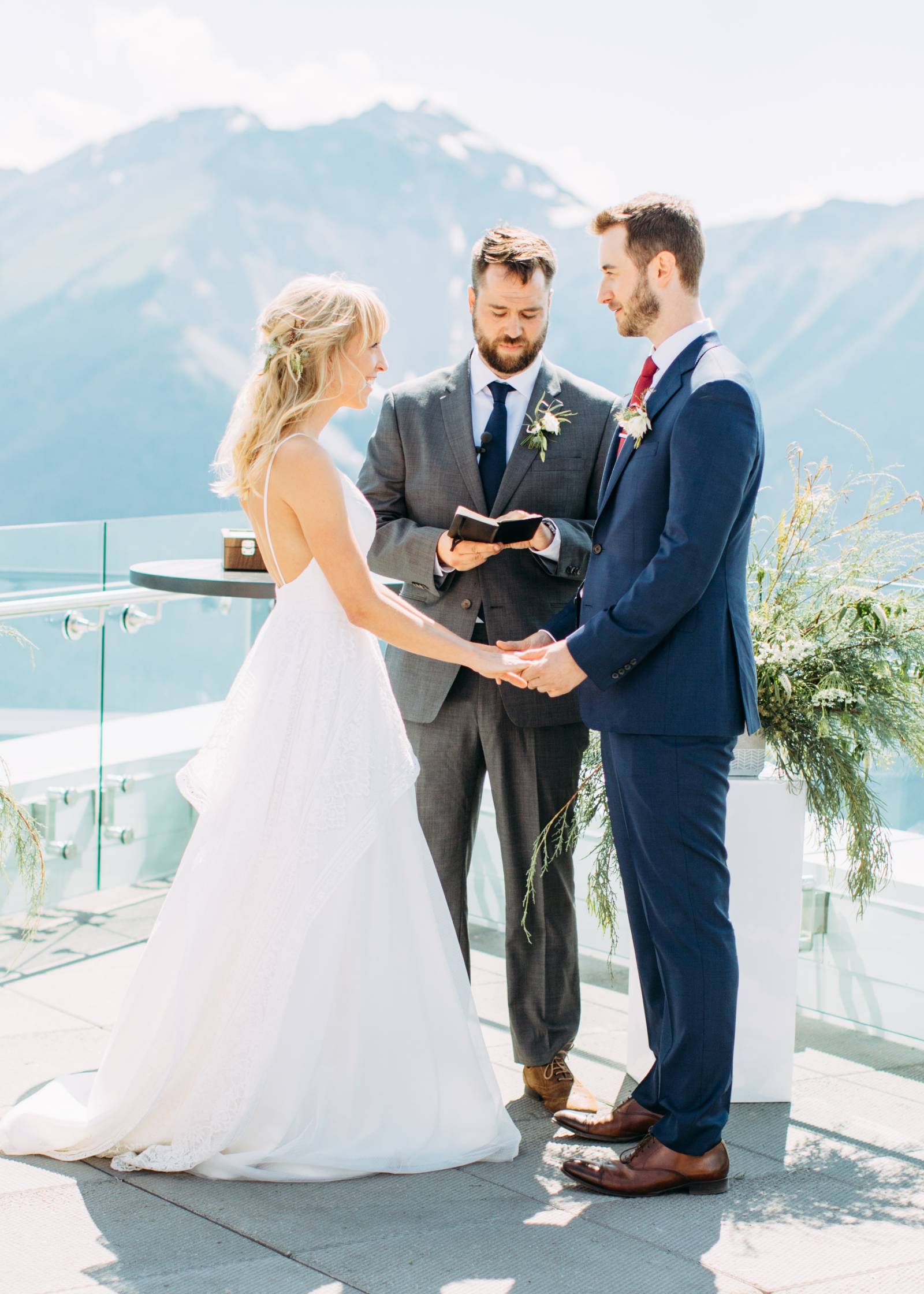 bride and groom holding hands at mountain top alter