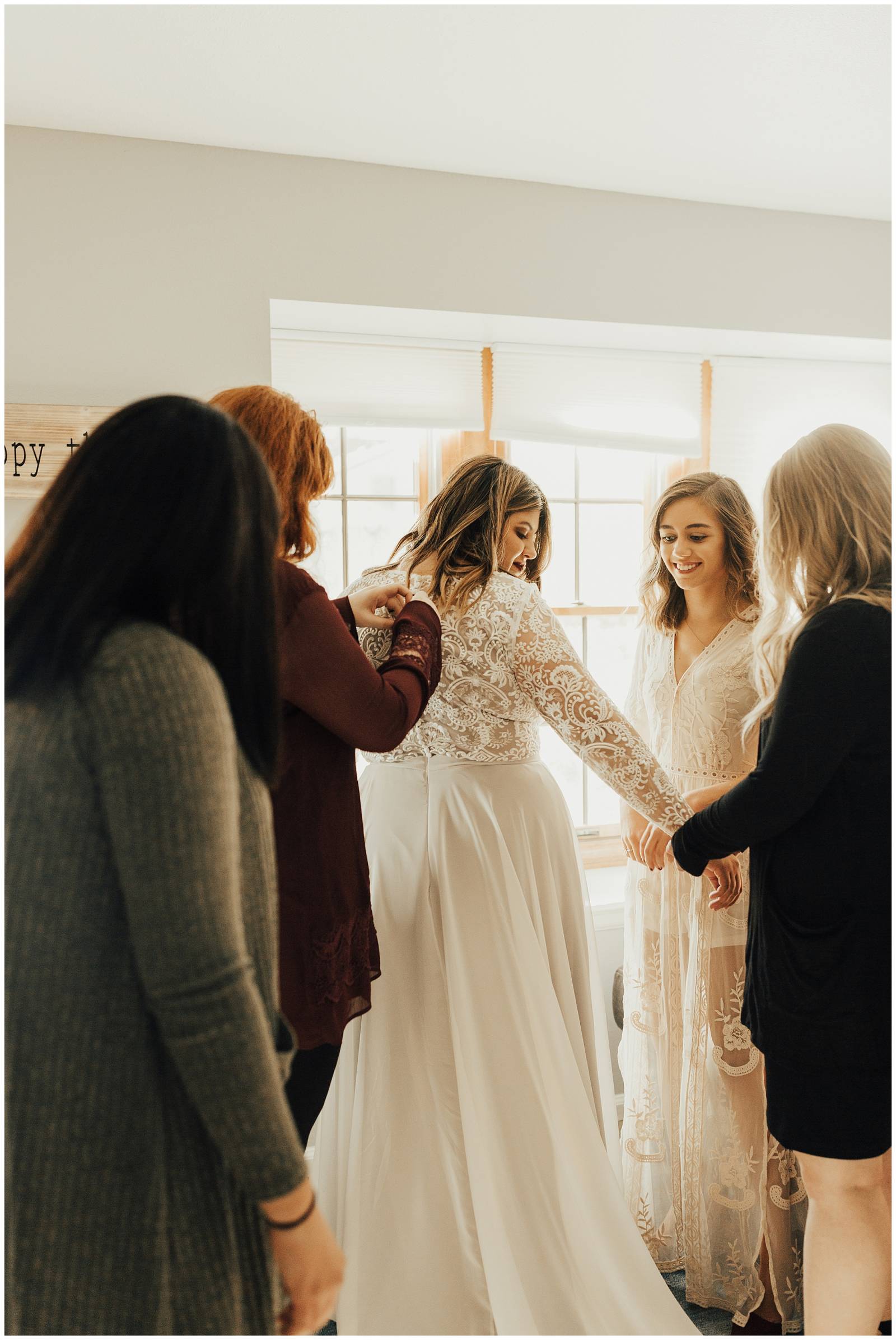 family helping bride button wedding gown | wedding getting ready inspiration