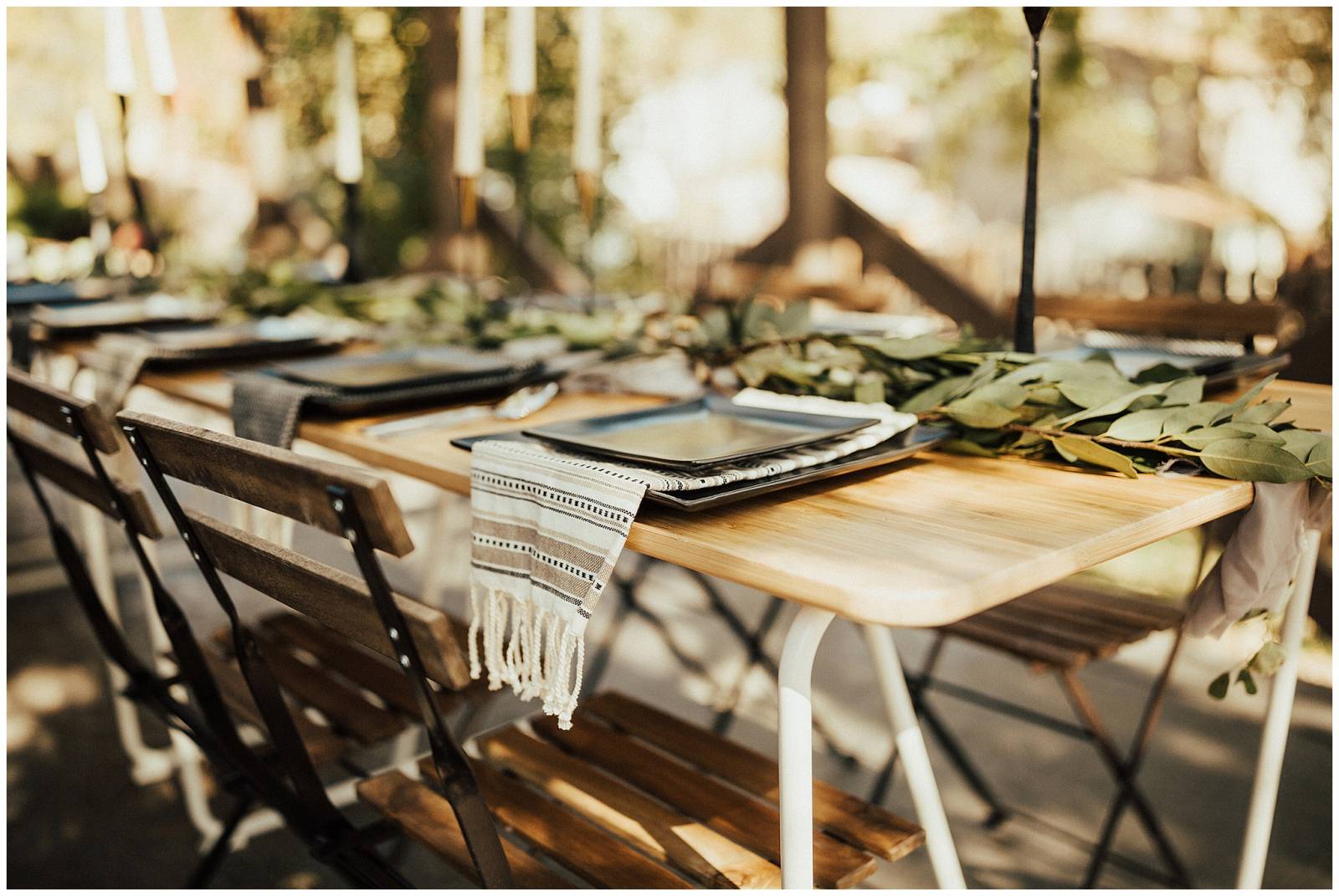natural outdoor wedding reception inspiration | wood table and chairs with black plates and green le