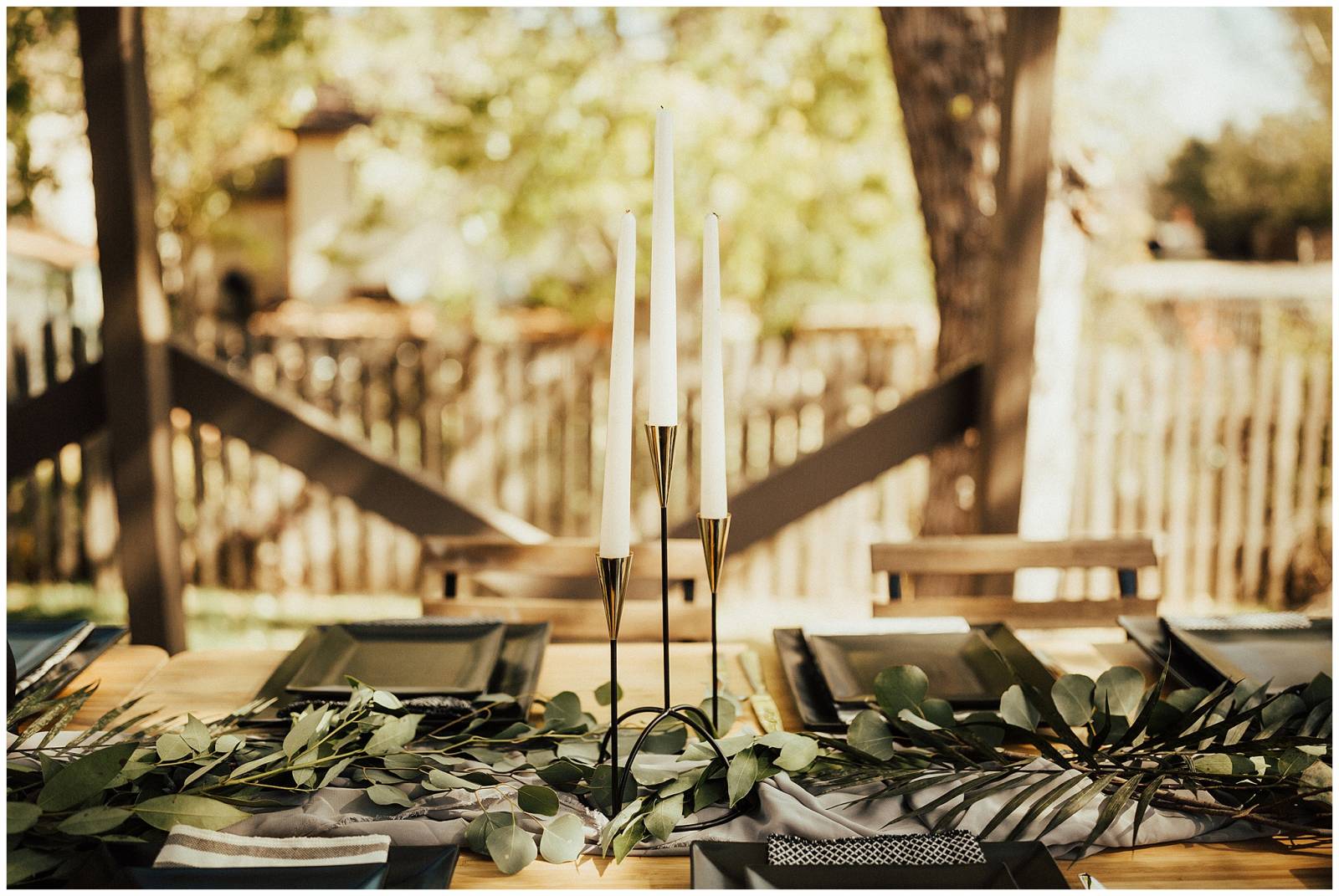 natural outdoor wedding reception inspiration | wood table and chairs with black plates and green le