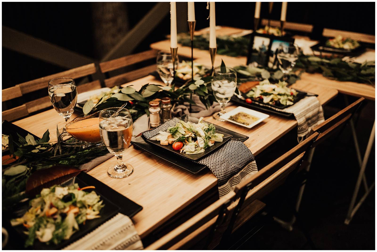 natural outdoor wedding reception inspiration | wood table and chairs with black plates and green le