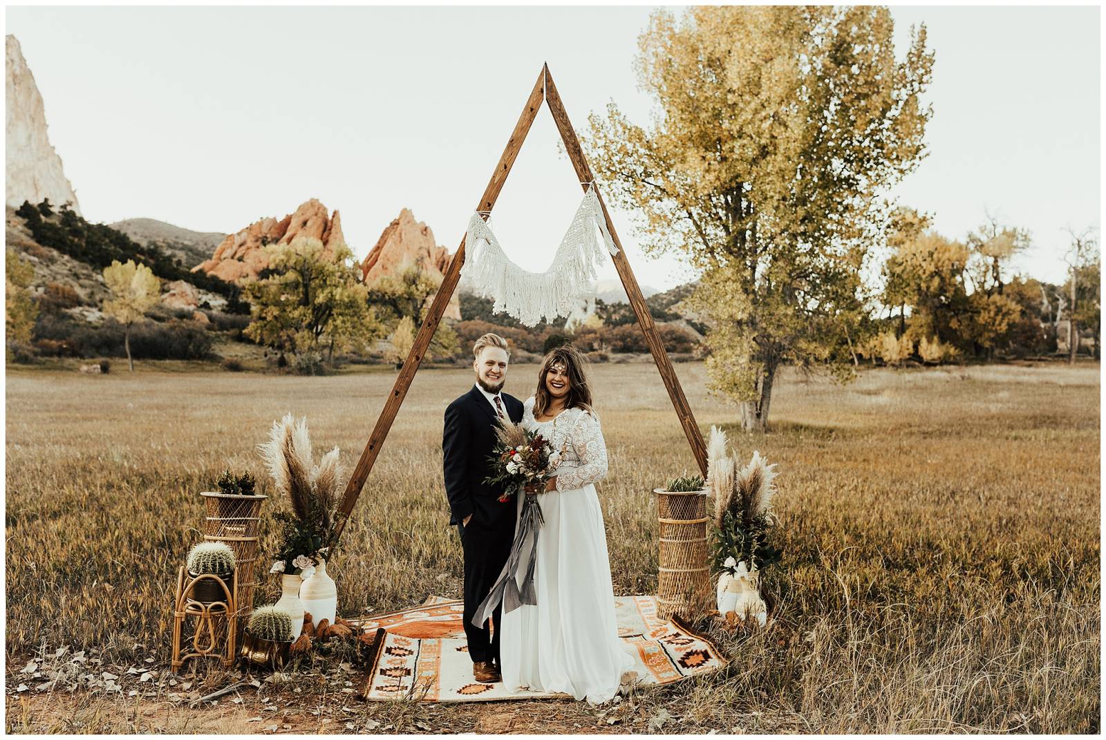 bride and groom posing under triangular wedding arbor | outdoor Colorado Springs wedding at the Gard