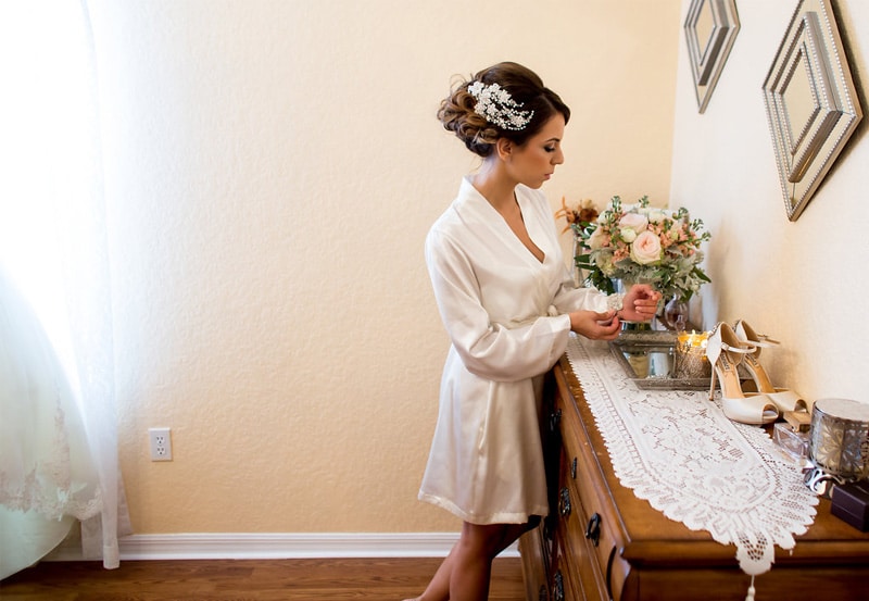 bride putting bracelet on before wedding