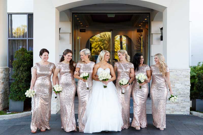bride walking with bridesmaids in gold sequin dresses
