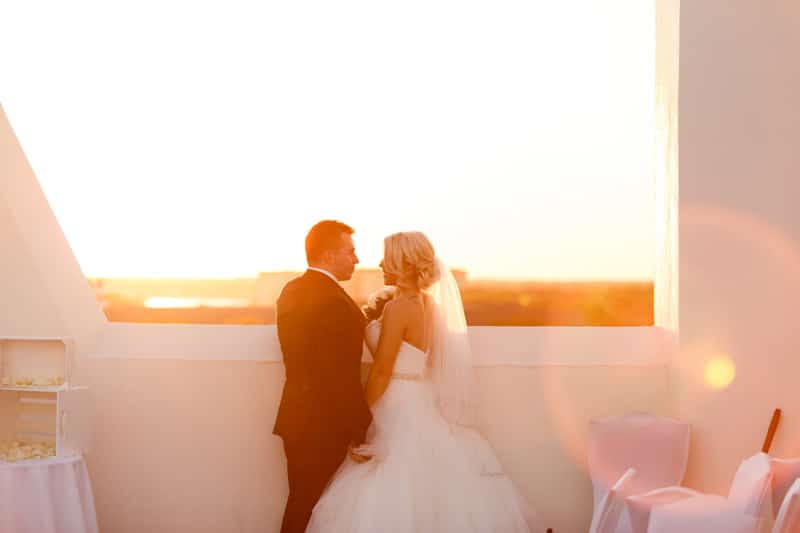 couple looking at each other on rooftop while sun is setting