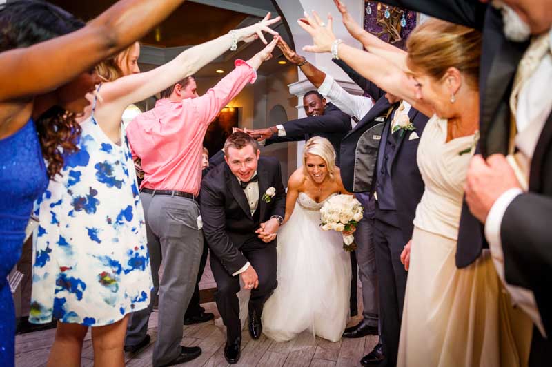couple walking under wedding guest arm tunnel