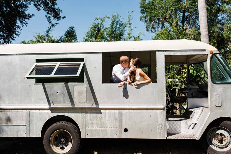 bride and groom kissing in old van
