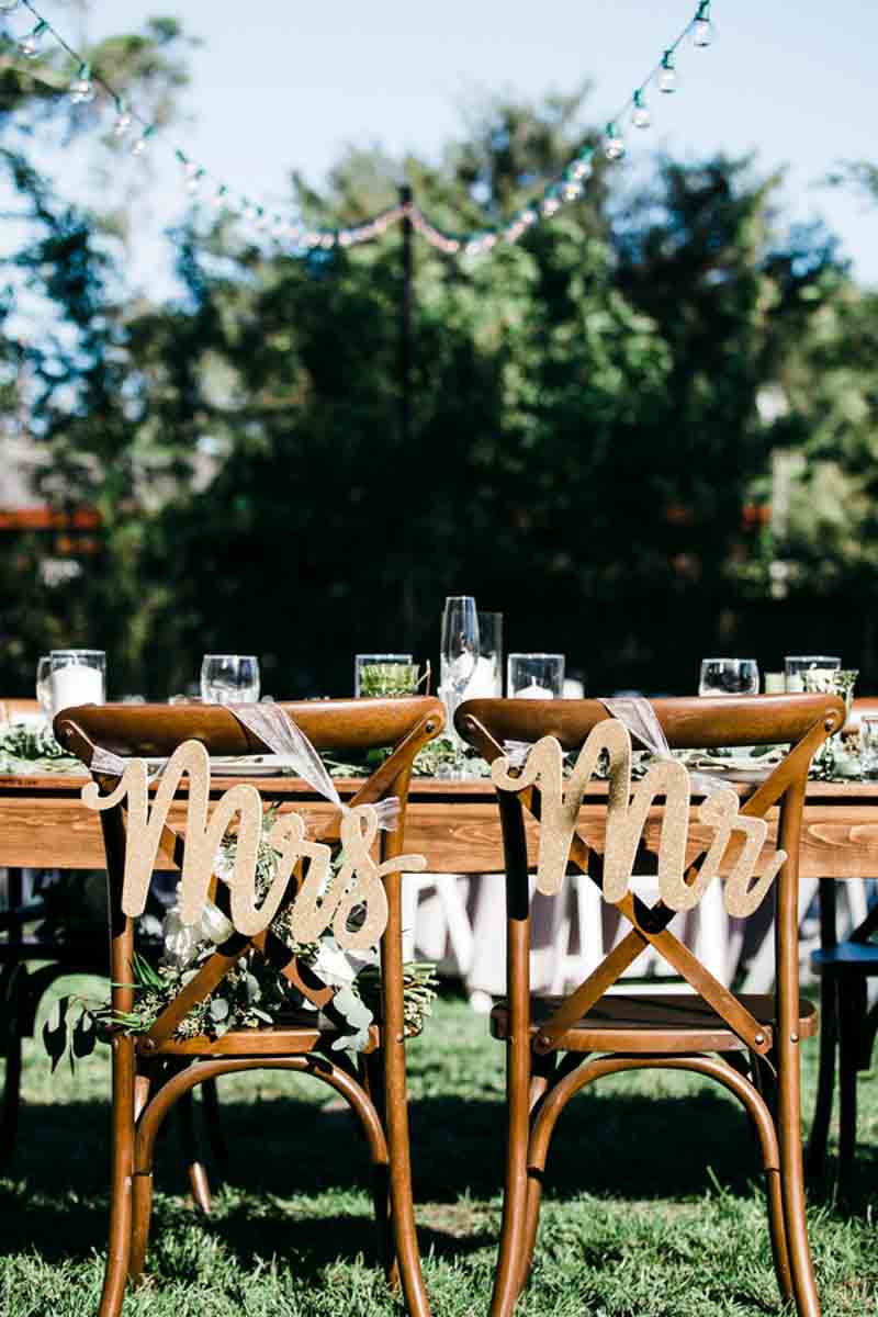 mr and mrs signs hanging from French country chairs