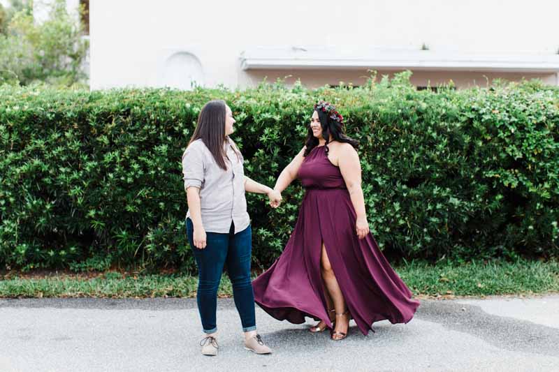 woman twirl in burgundy dress holding partner's hand