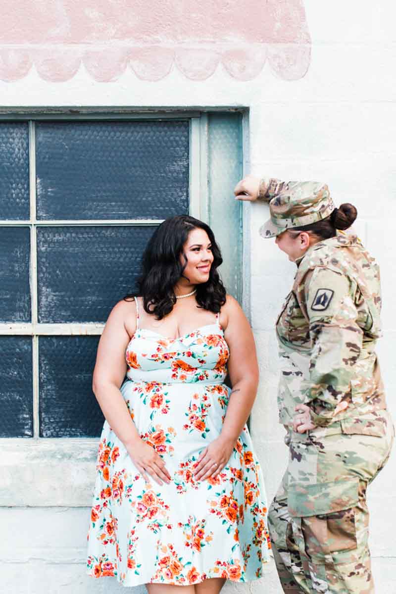 woman leaning on wall looking at fiance