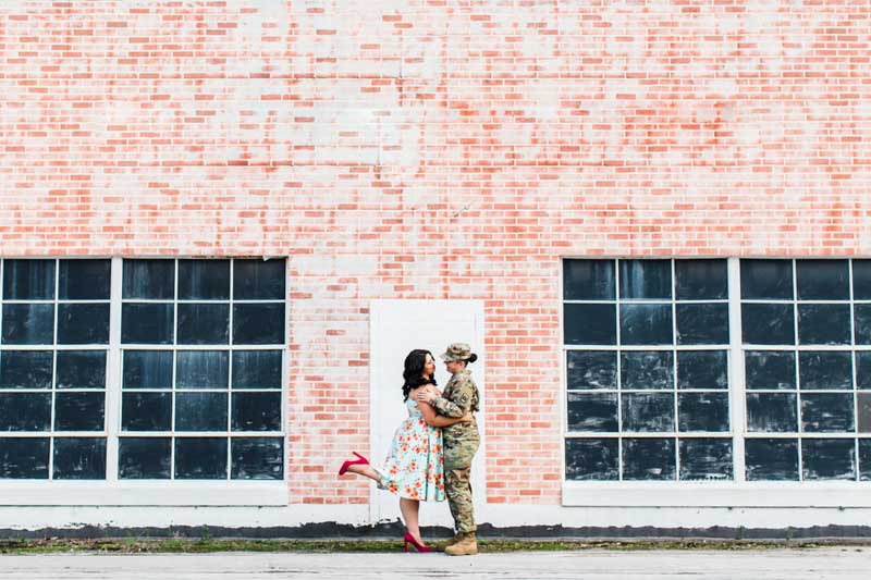 women standing in front of brick wall for engagement session