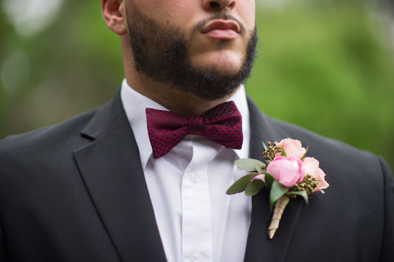 groom wearing red bowtie and pink boutonniere