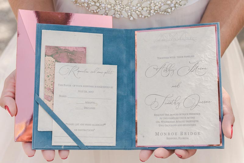 bride holding wedding invitation suite