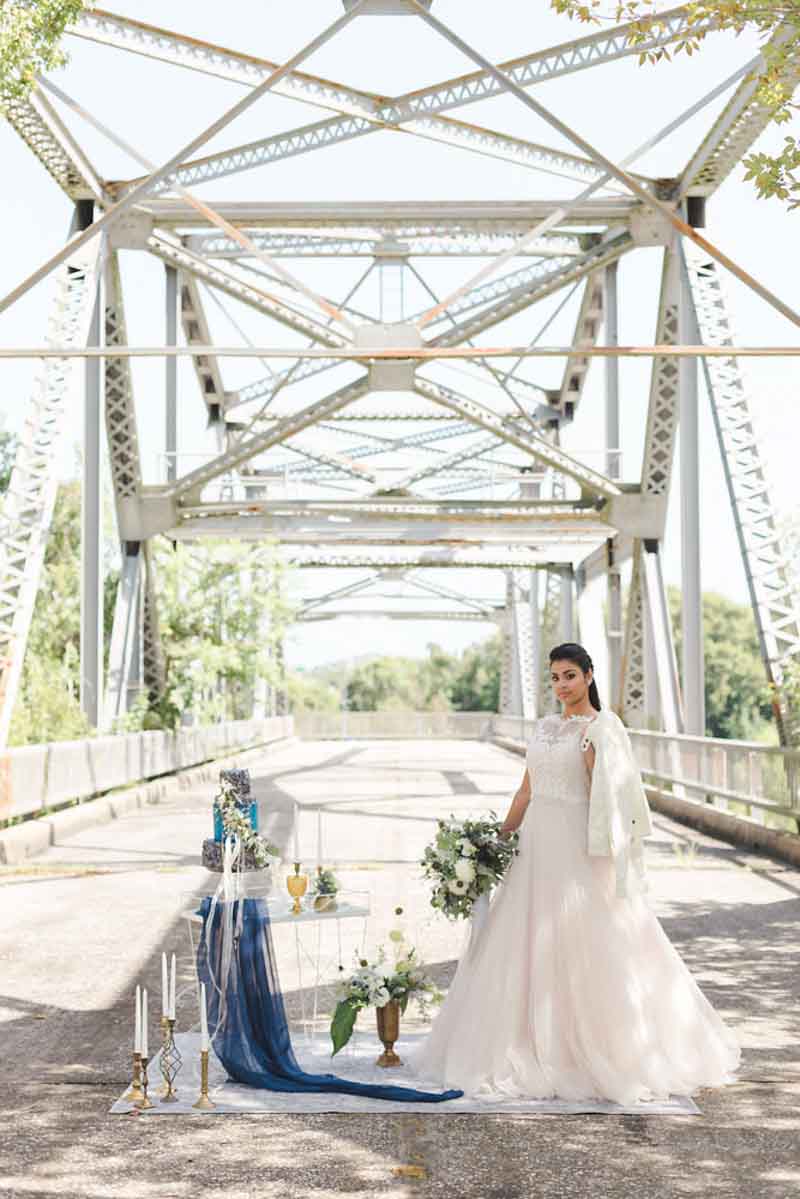 bride standing on bridge for industrial elegance wedding shoot