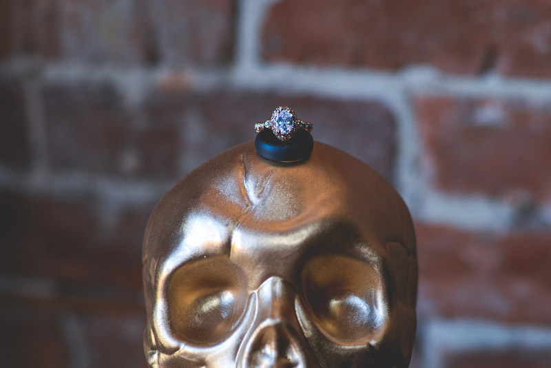 rose gold engagement ring on gold skeleton head