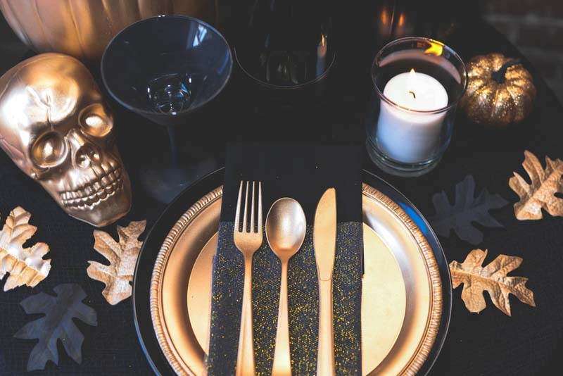 gold flatware on black and gold napkin