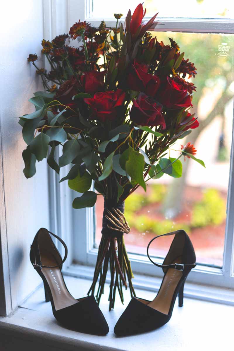 red rose bouquet by black wedding heels