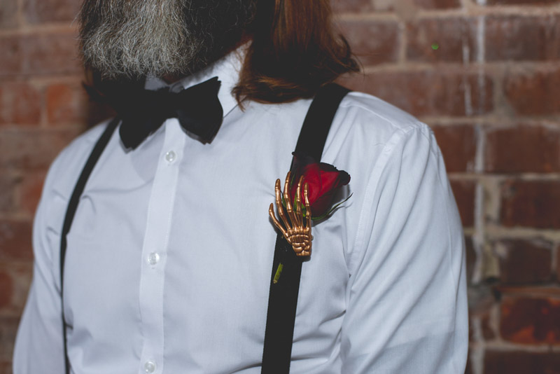 skeleton hand holding red rose boutonniere
