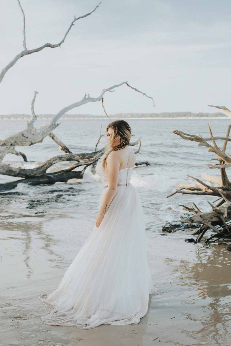 bride looking over shoulder on beach