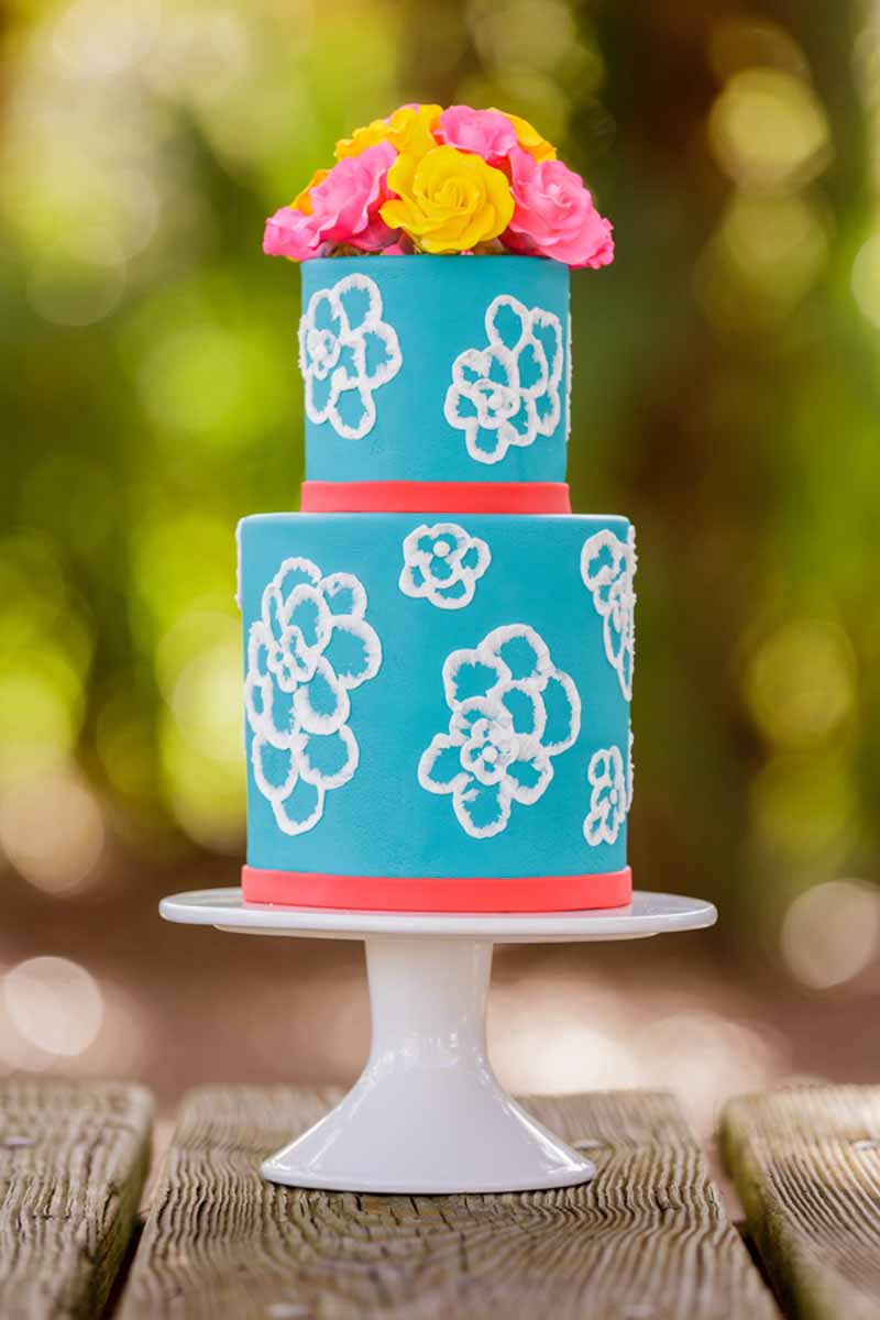 blue wedding cake with white flowers on white cake stand