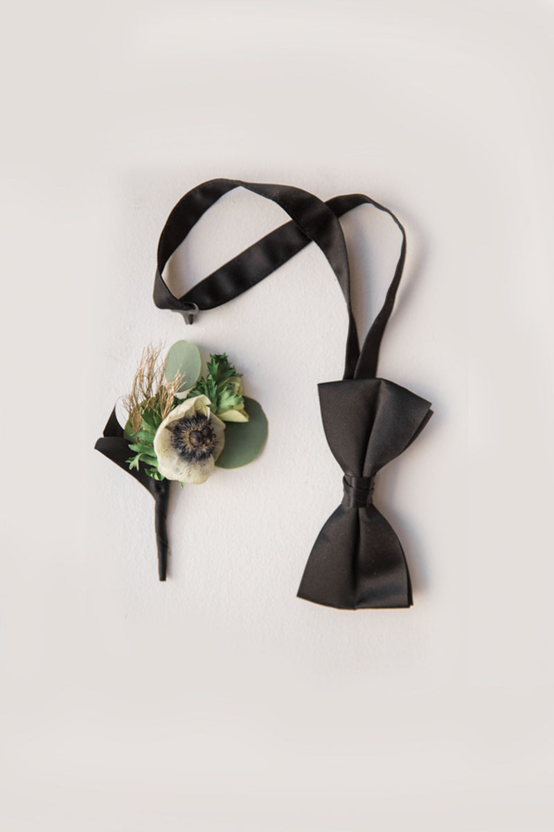 black bowtie next to boutonniere
