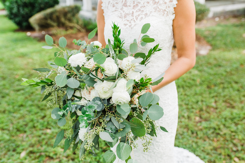bride holding greenery and white bridal bouquet
