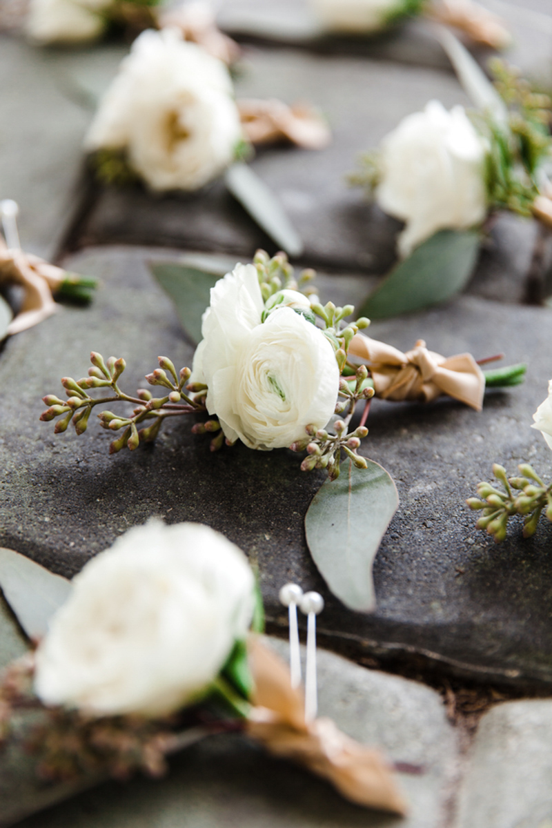 white boutonnieres on cobblestone walkway